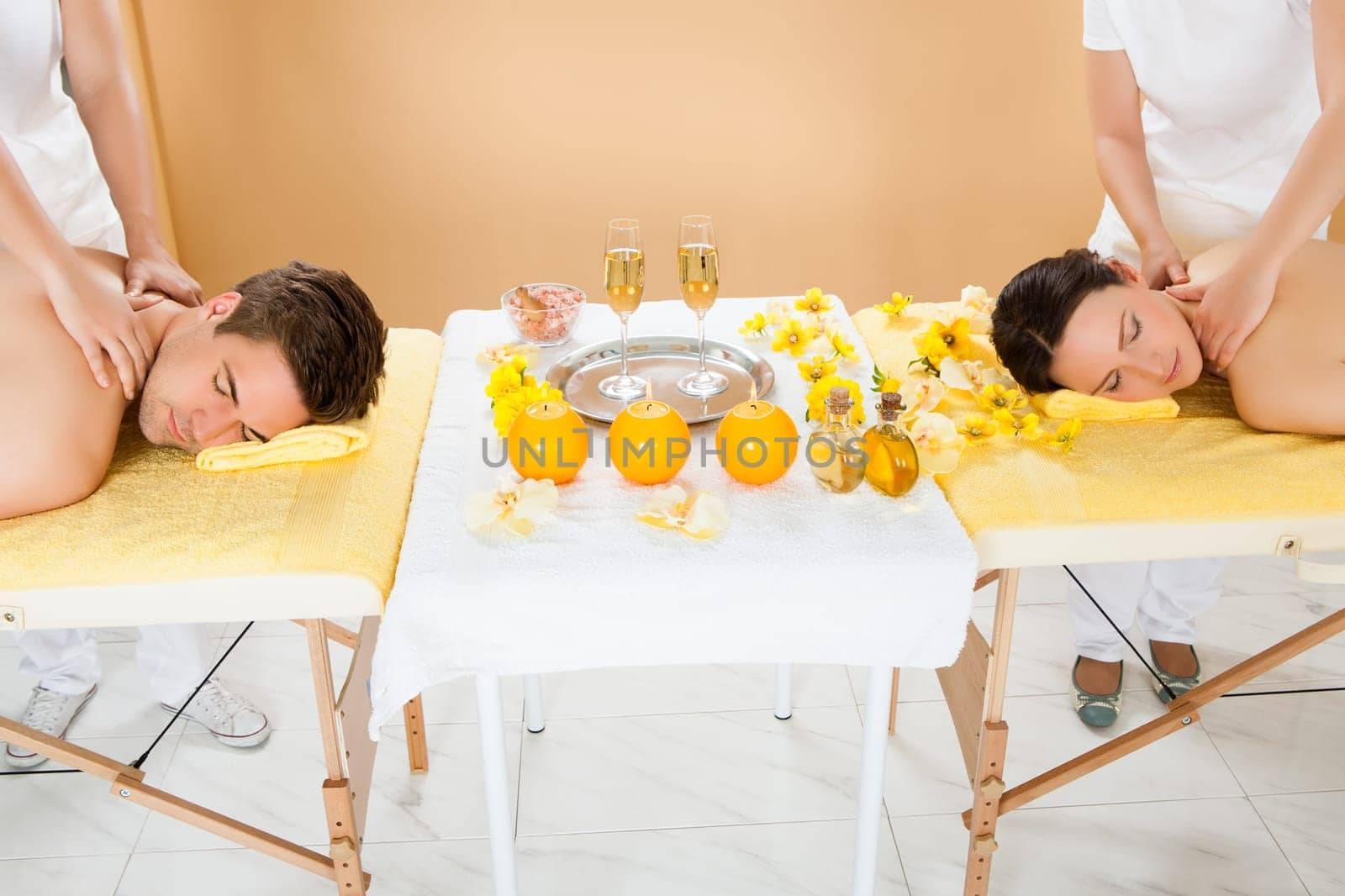 Relaxed young couple receiving shoulder massage at beauty spa