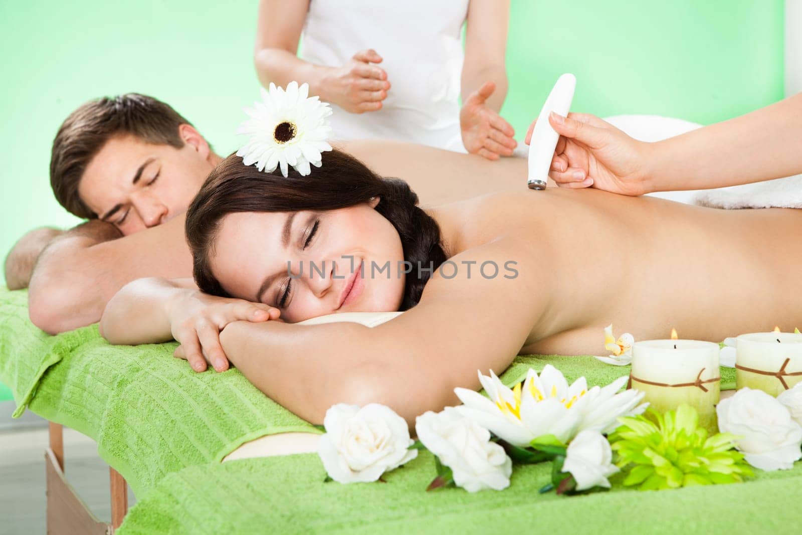 Young couple receiving microdermabrasion therapy at beauty spa with her man