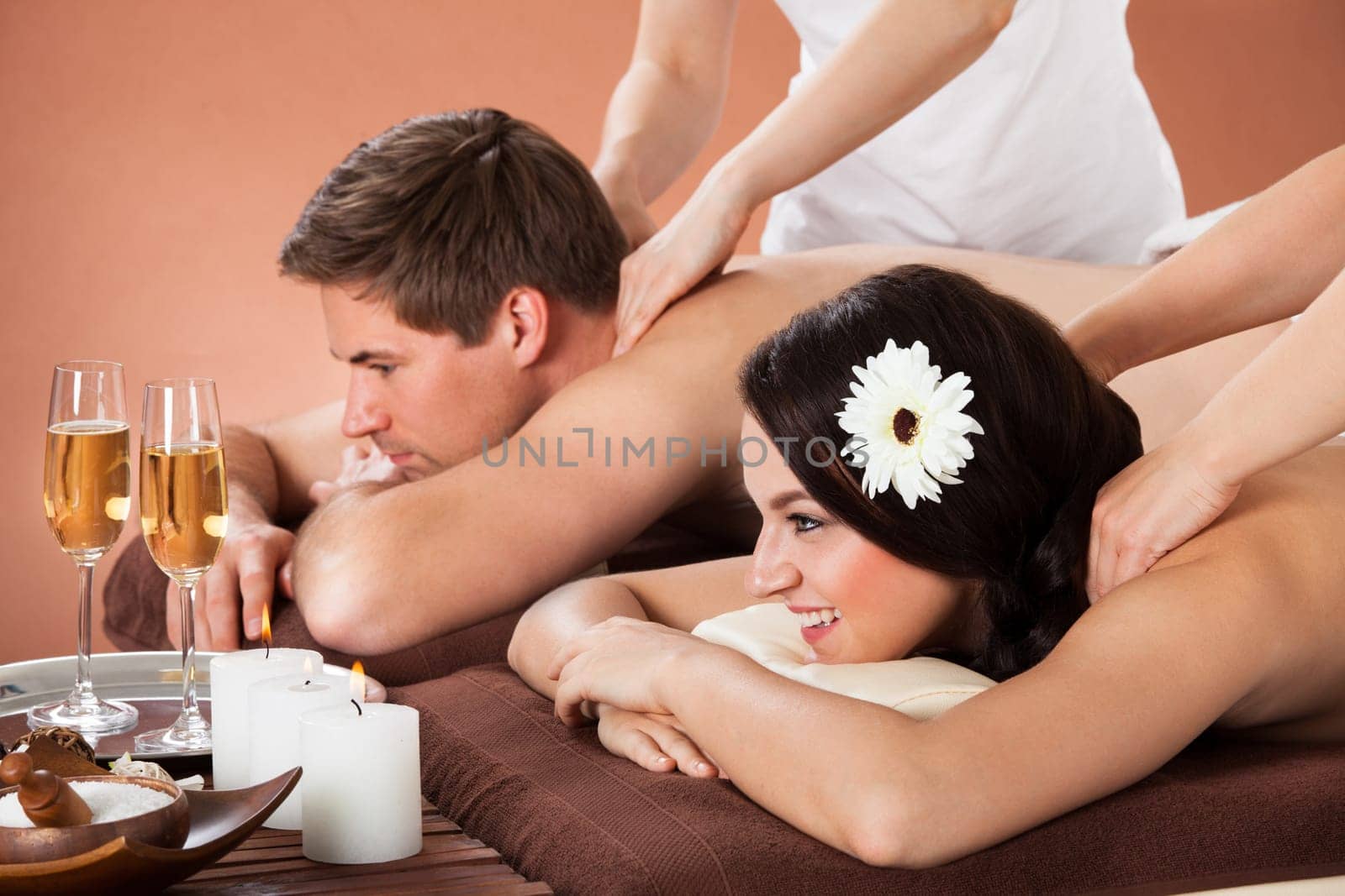 Relaxed young couple enjoying shoulder massage at beauty spa