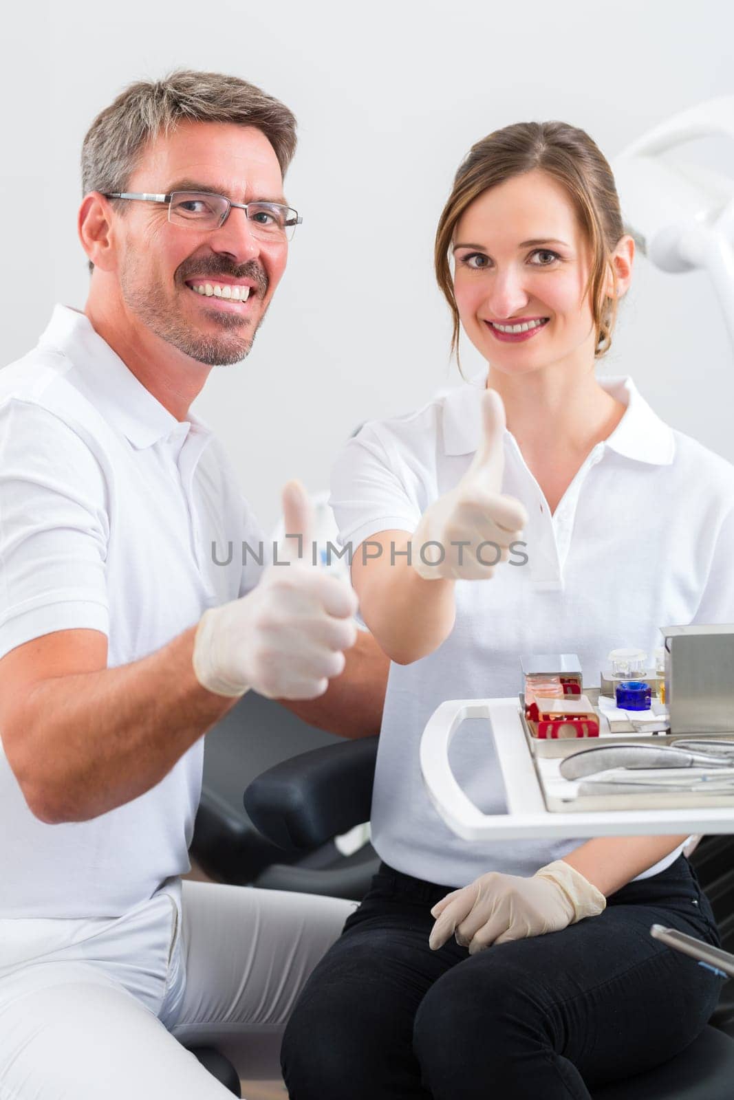 Female patient with dentist and dental assistant during treatment