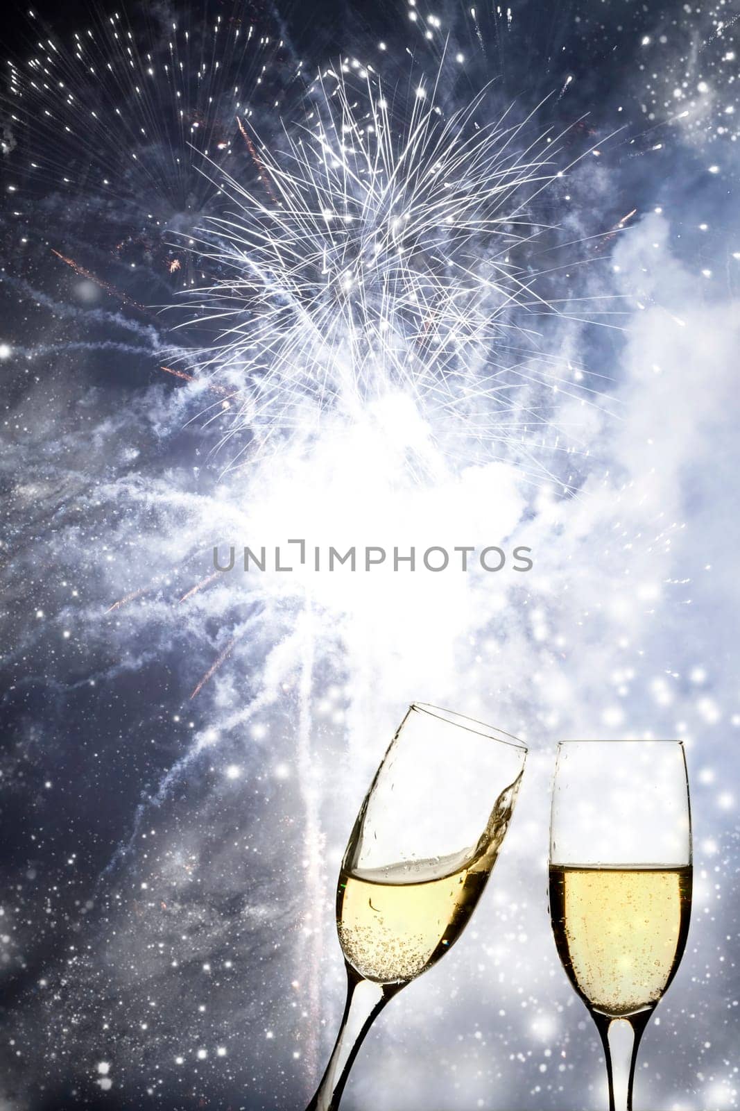 Glasses with champagne against fireworks and holiday lights