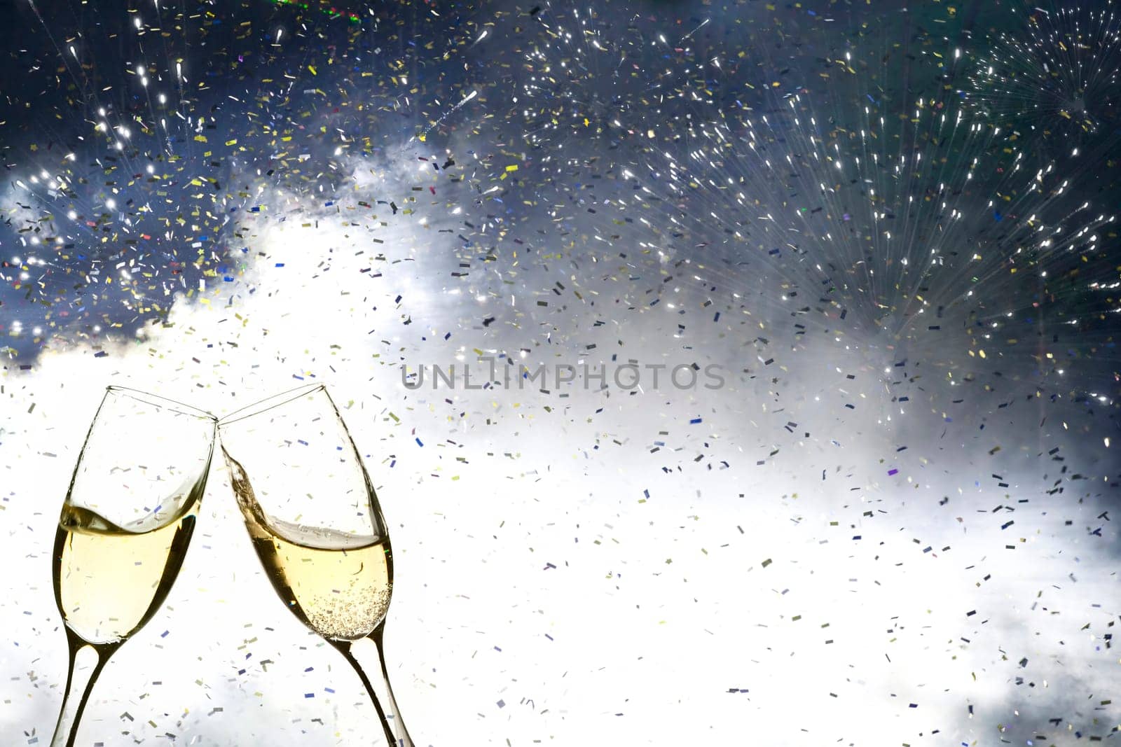 Glasses with champagne against fireworks and holiday lights