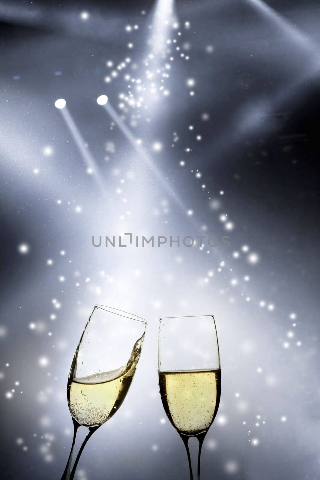Glasses with champagne against fireworks and holiday lights