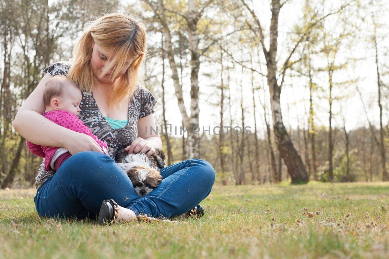 Mother is having a trip with the baby and dog outside