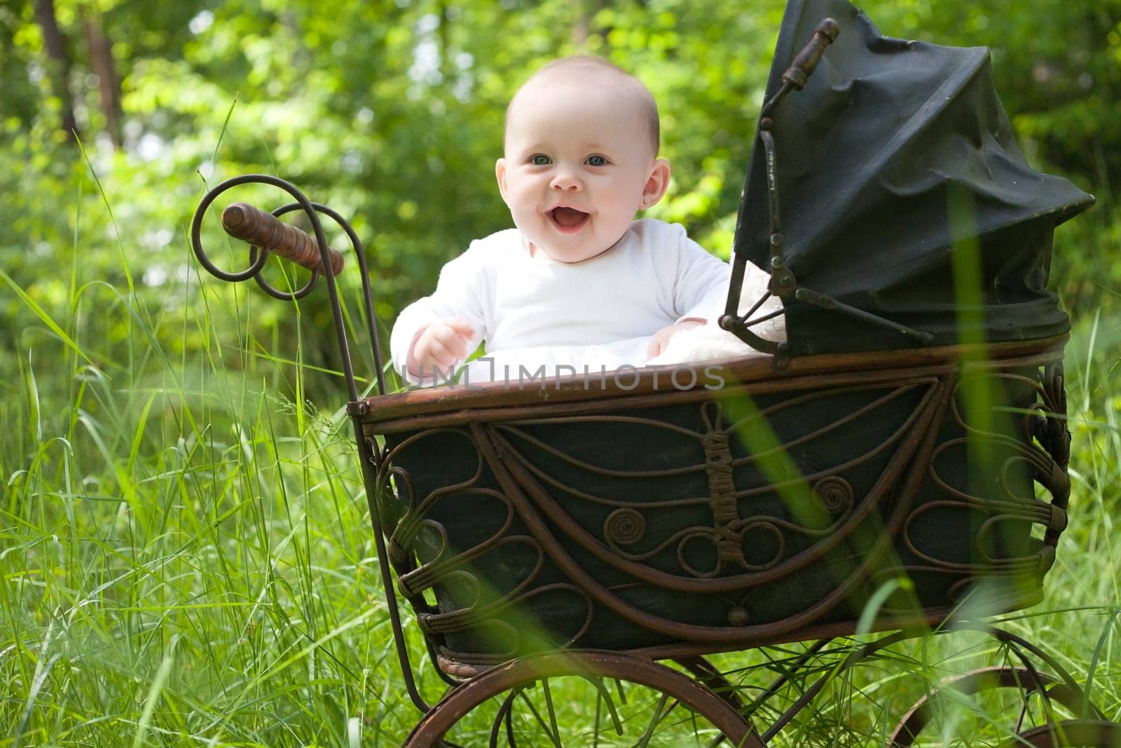 Baby girl is sitting in a vintage pram