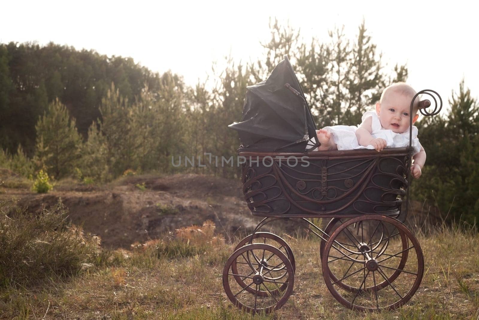 Baby girl is sitting in a vintage pram