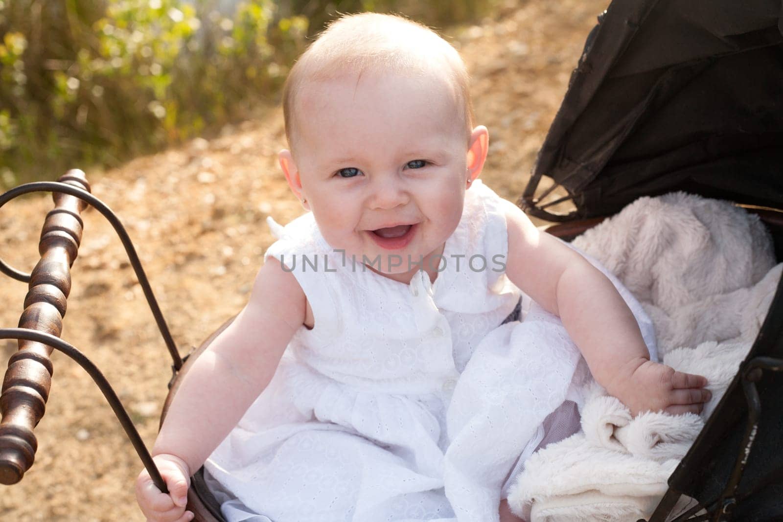 Baby girl is sitting in a vintage pram