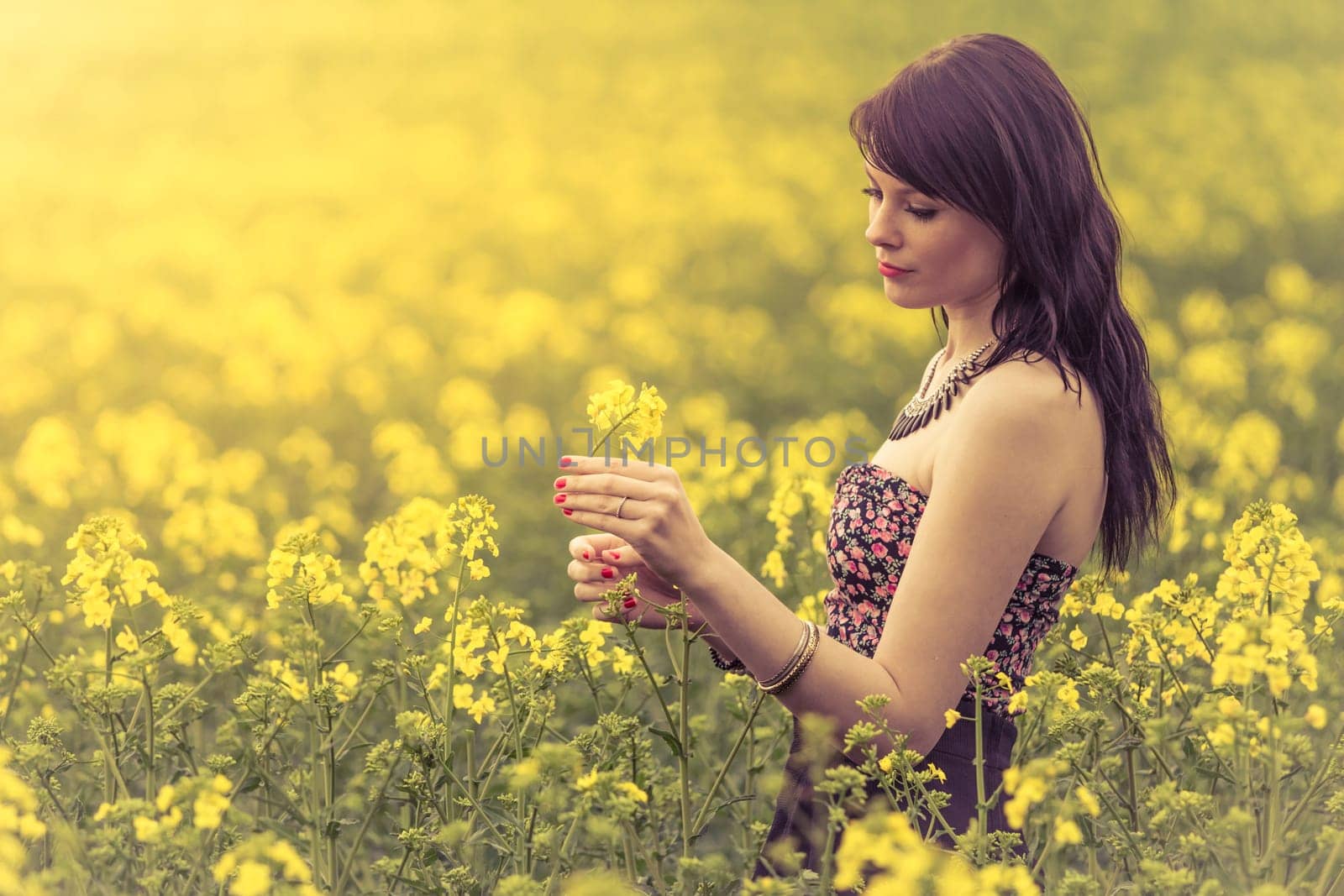 Attractive genuine young girl enjoying the warm summer sun in a wide green and yellow meadow. Part of series.