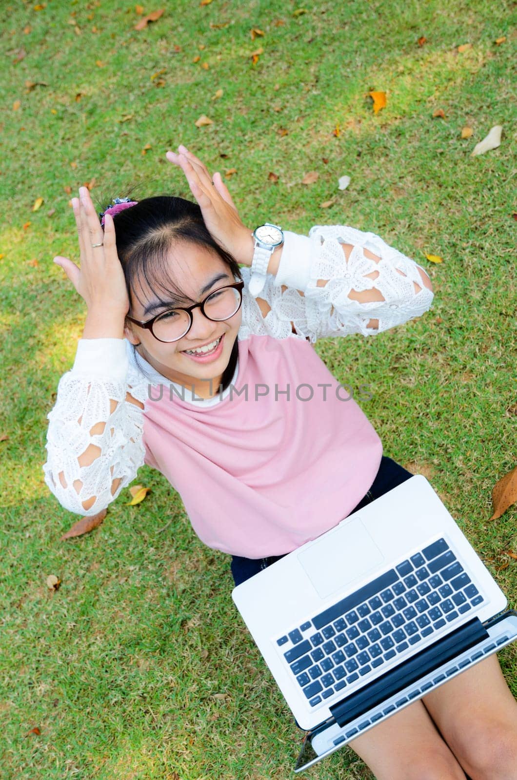 Cute girl is happy with notebook on grass in park