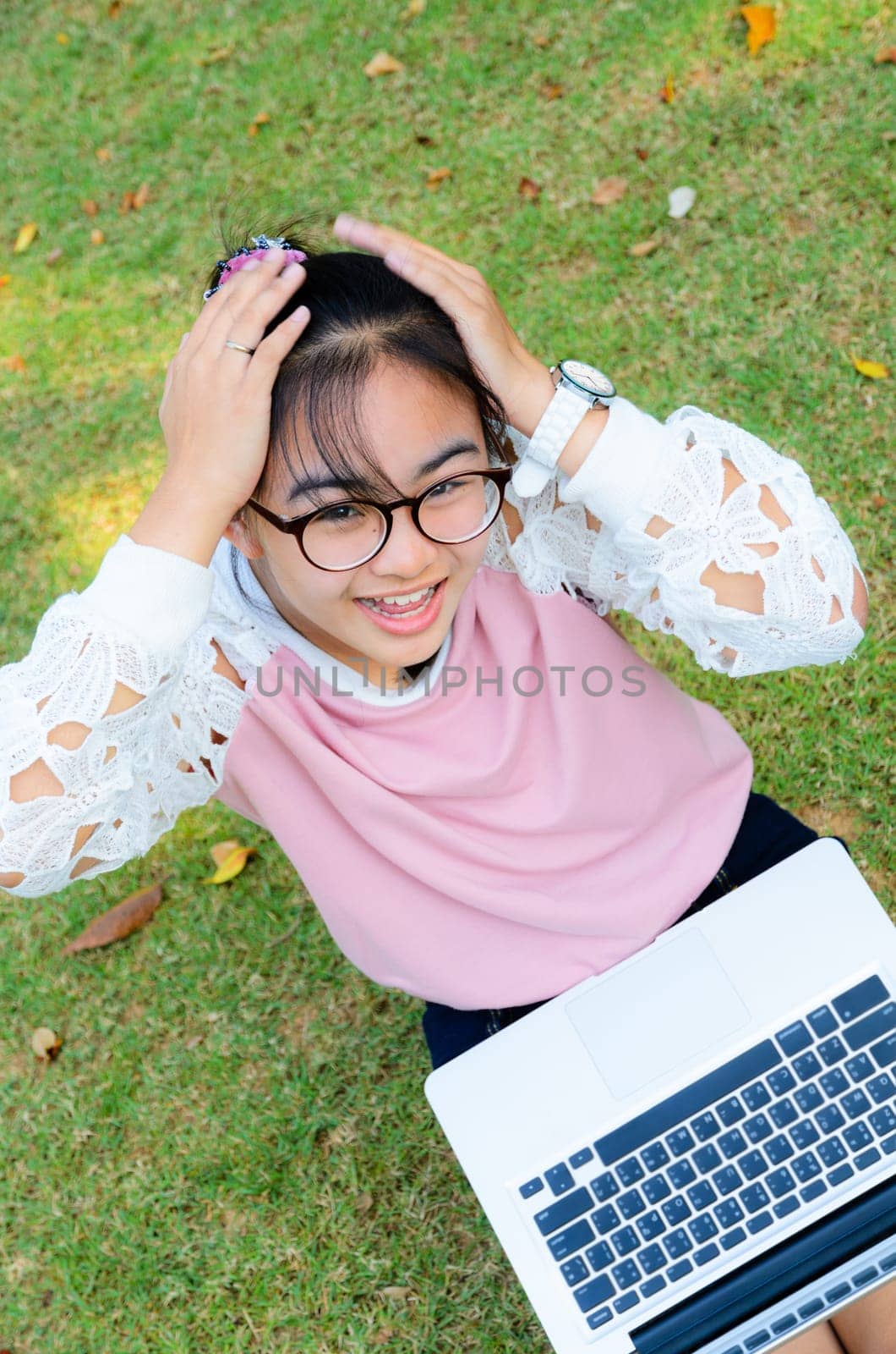 Cute girl is happy with notebook on grass in park