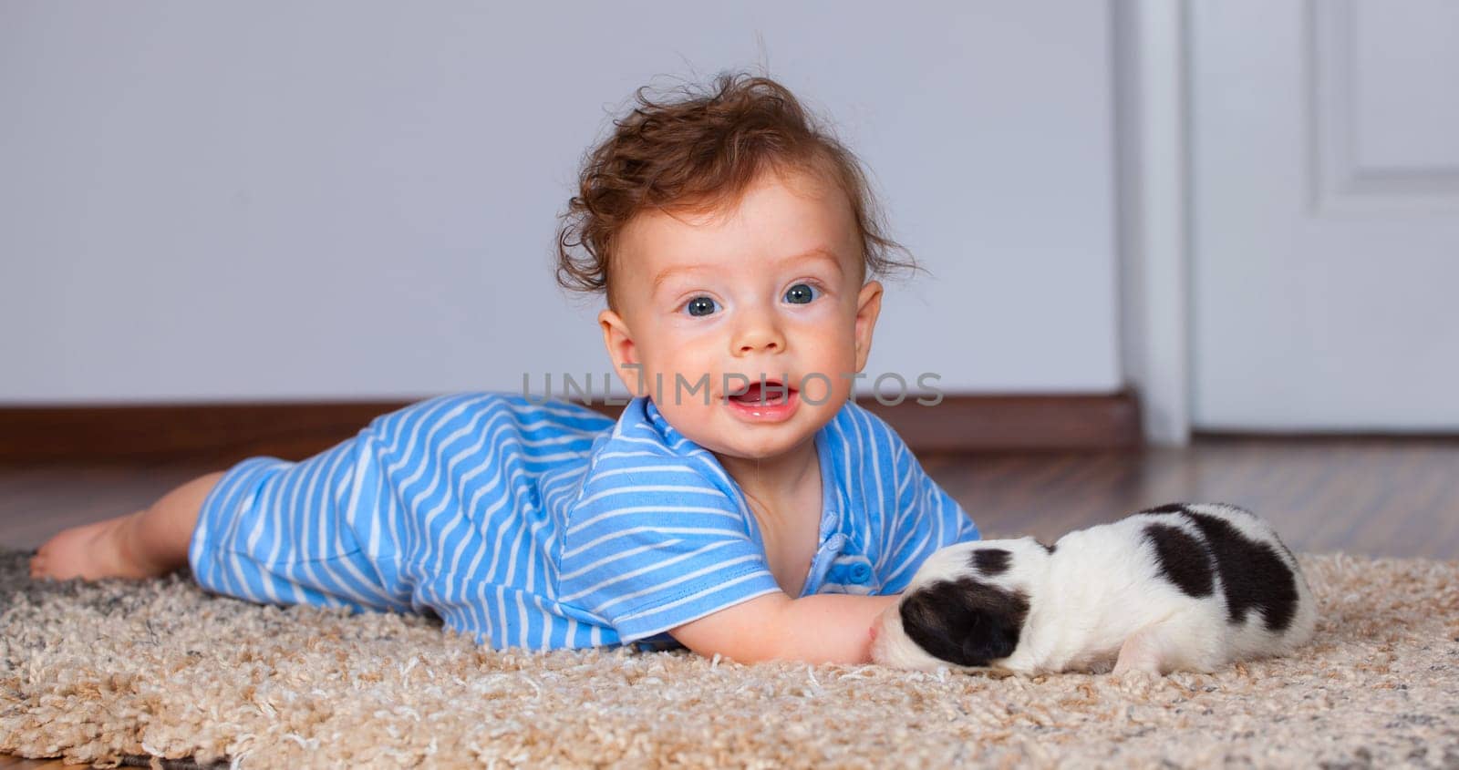 7 months old baby boy playing with new born pup.