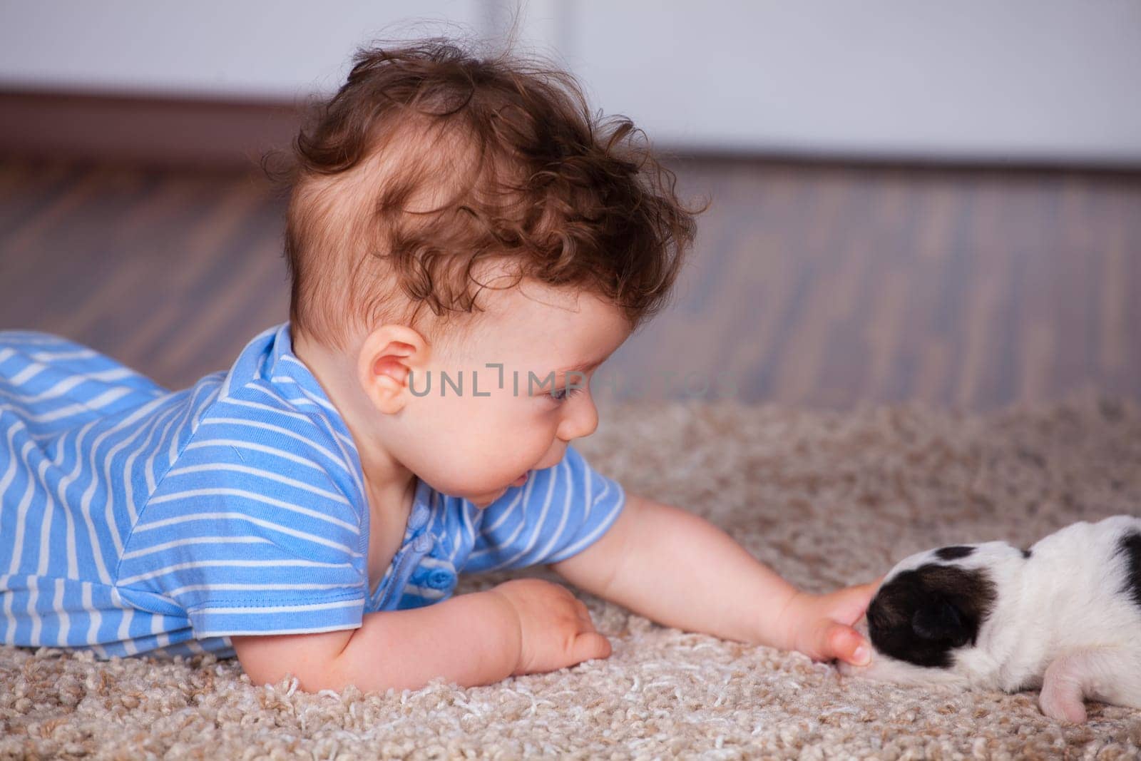 7 months old baby boy playing with new born pup.