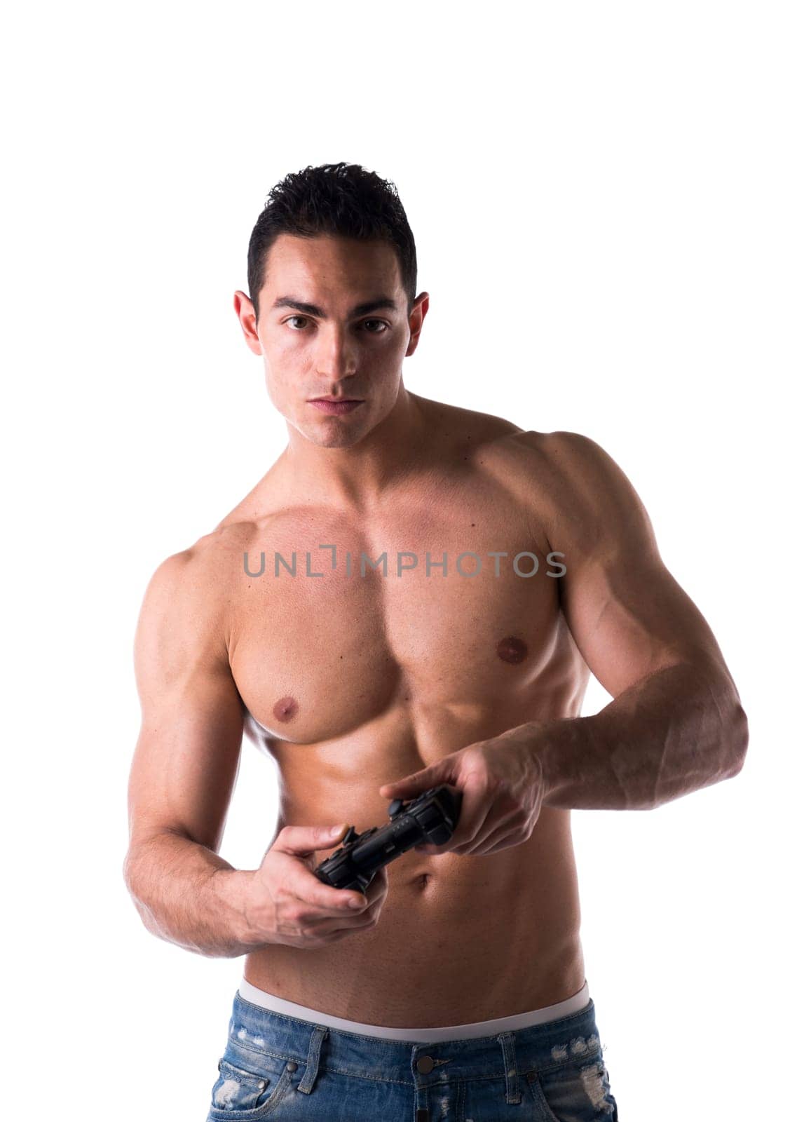 Muscular shirtless young man playing a video game with joystick in hands, isolated on white