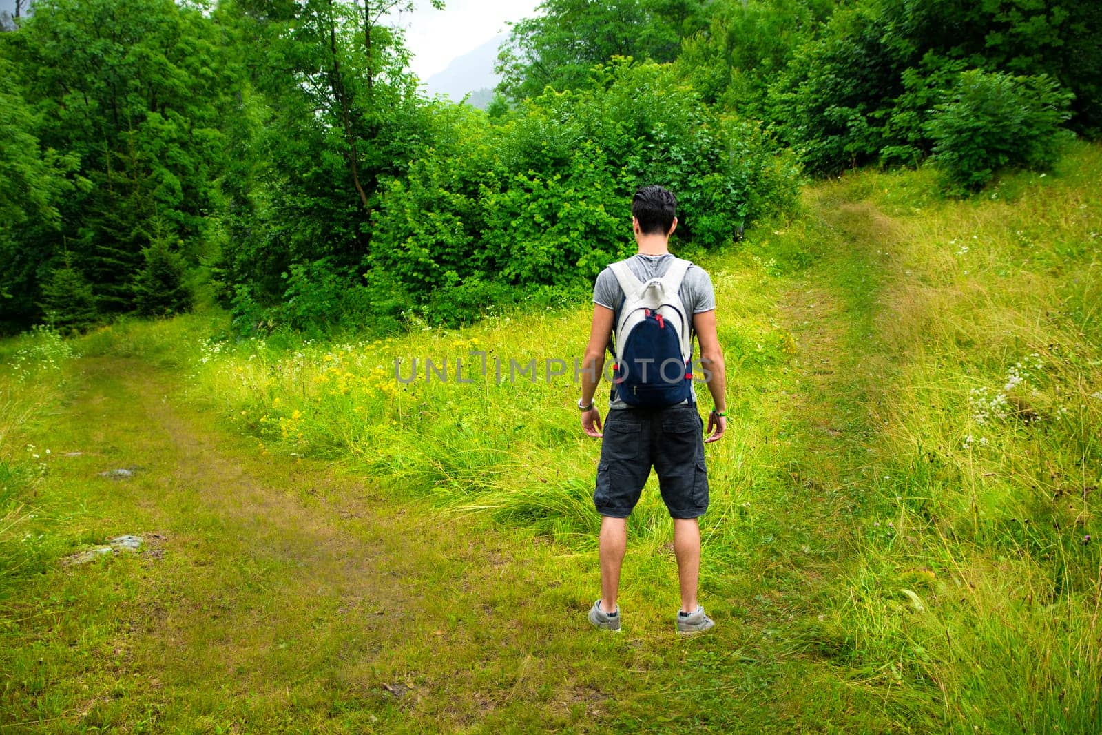 Young man facing choice between two different paths. Concept of choosing between options