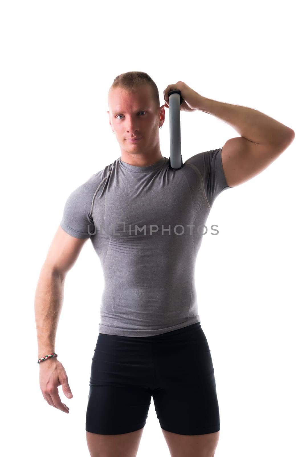 Sexy muscular man, working out with pilates ring on shoulder, isolated on white