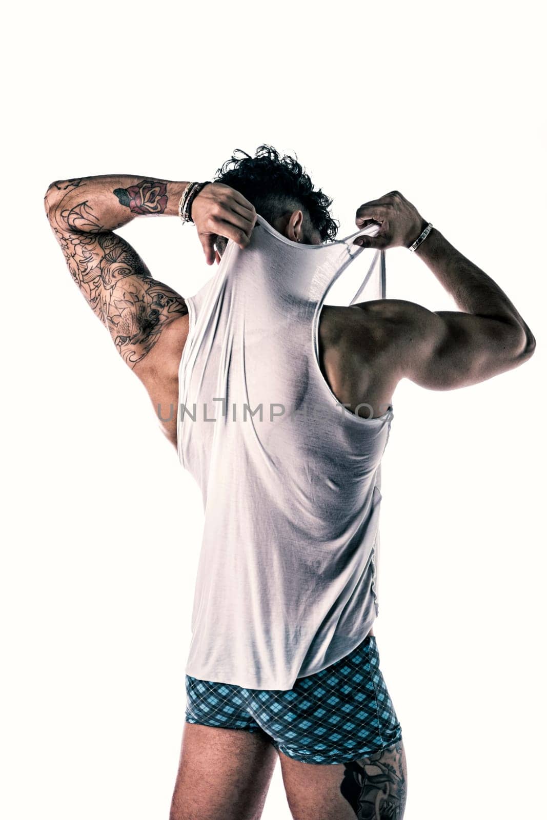 Back of strong and healthy young man posing in tank top isolated on white