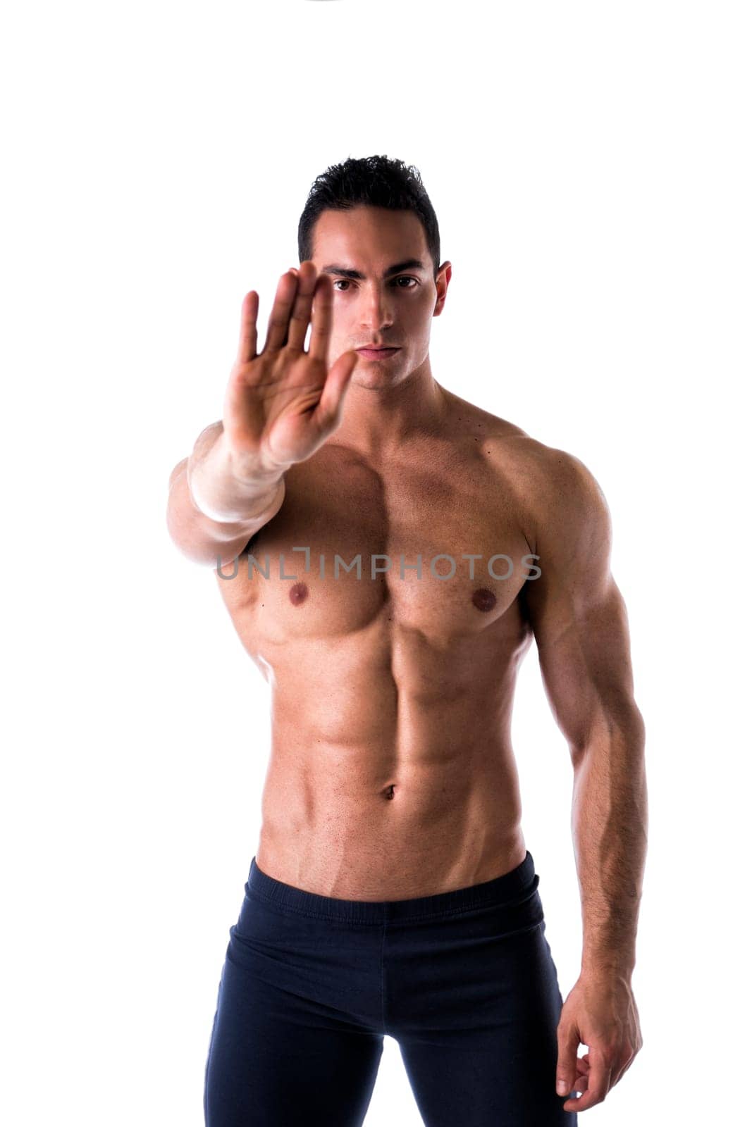 Defiant stern man making a Halt or Stop gesture holding his hand extended to the camera denying access, calling for a halt or finish, a stop, or indicating he has had enough and to go away