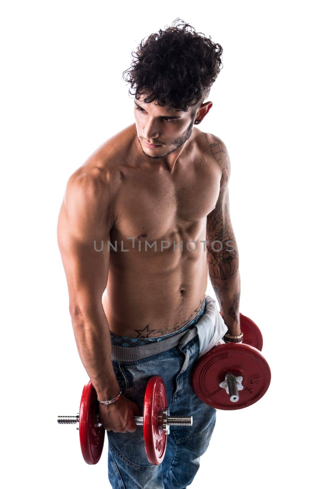 Handsome shirtless muscular young man holding dumbbells poses isolated on white