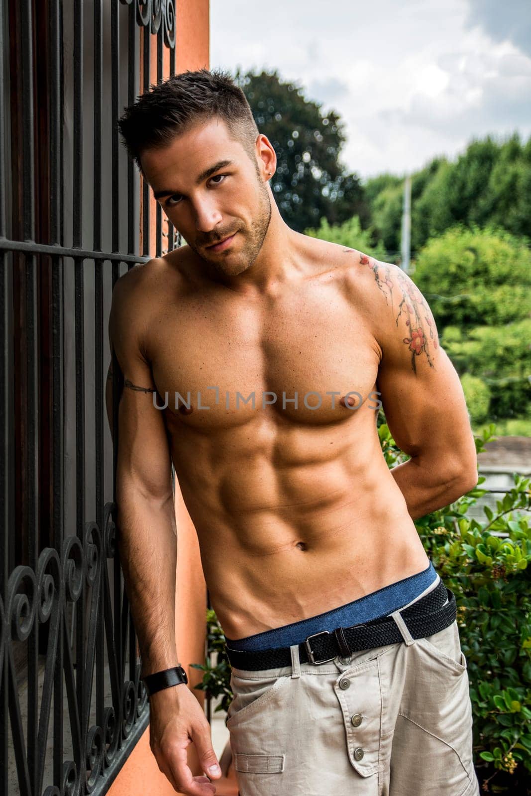 Handsome shirtless young man outdoor, looking at camera