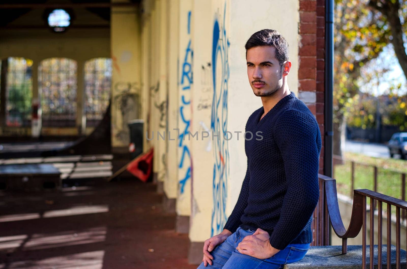 Handsome young man in grunge building looking away, large copy-space