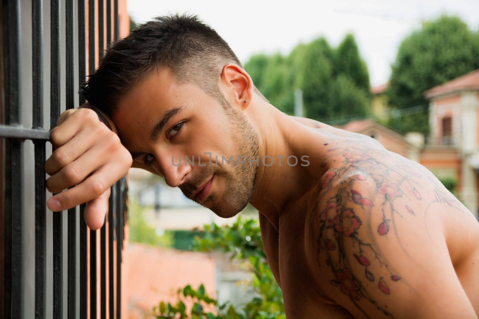 Handsome shirtless young man outdoor, looking at camera