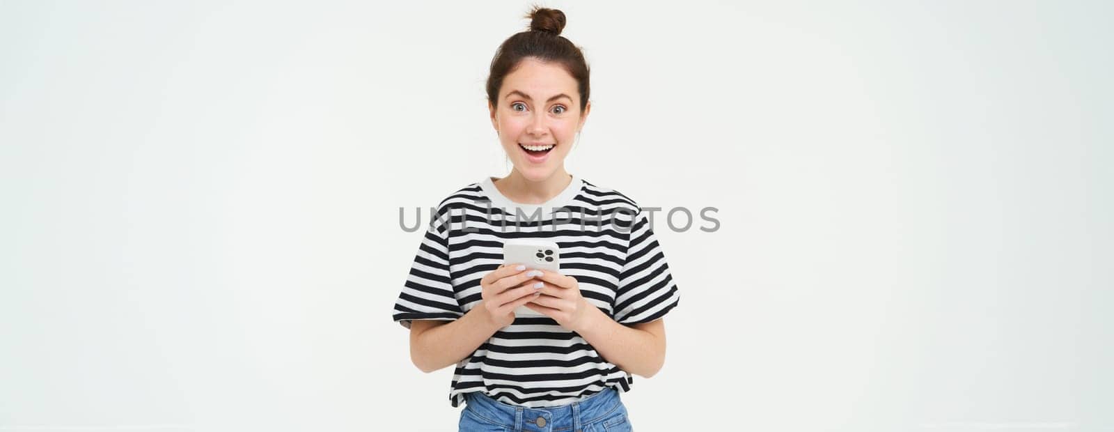 Technology and people concept. Young woman with mobile phone, smiling, using smartphone app, social media application, isolated over white background by Benzoix