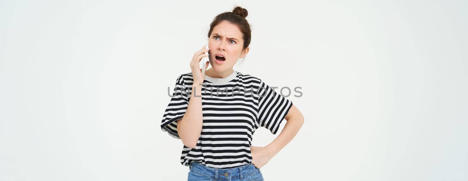 Angry woman shouts at mobile phone, argues at someone over the telephone, has intense conversation over smartphone, white background by Benzoix