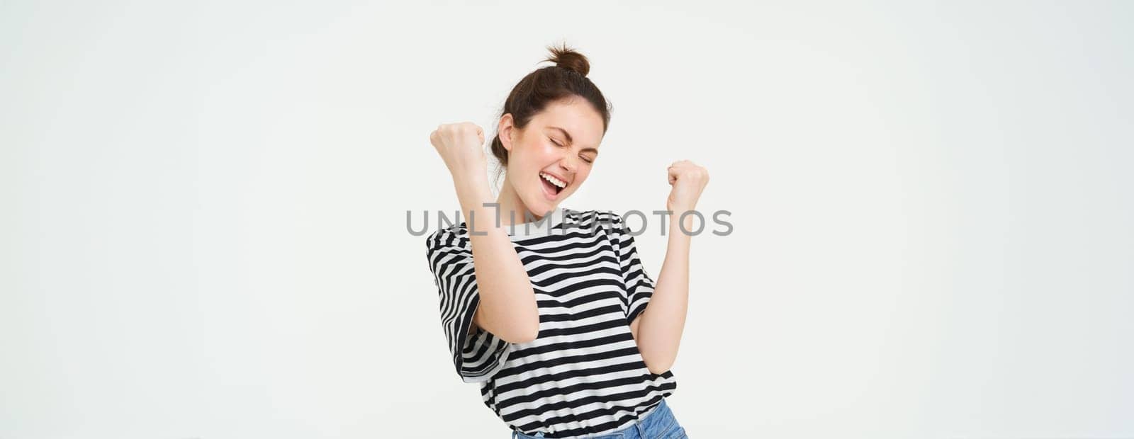 Portrait of happy woman winning, celebrating victory, rooting for team, triumphing, standing over white background by Benzoix