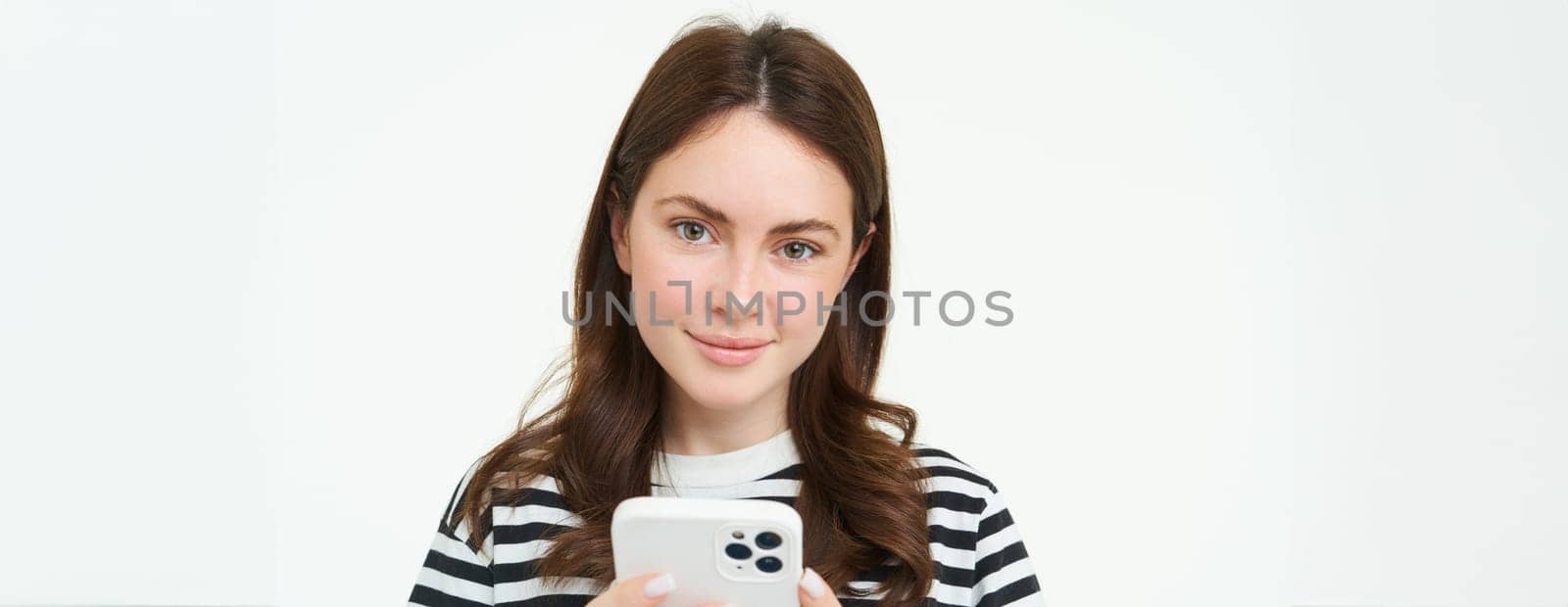 Portrait of woman checking her messages on mobile phone, looking at smartphone screen by Benzoix
