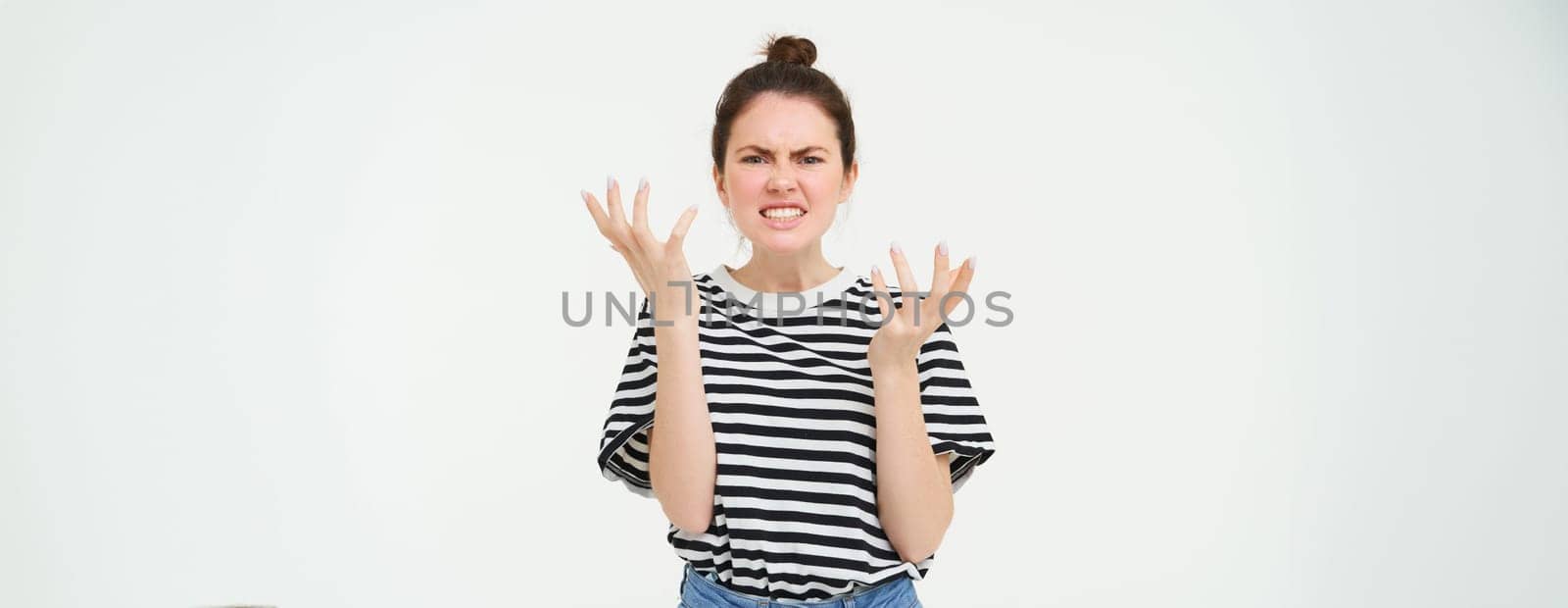 Portrait of angry woman shouting and shaking hands, losing her temper, arguing, standing over white background.