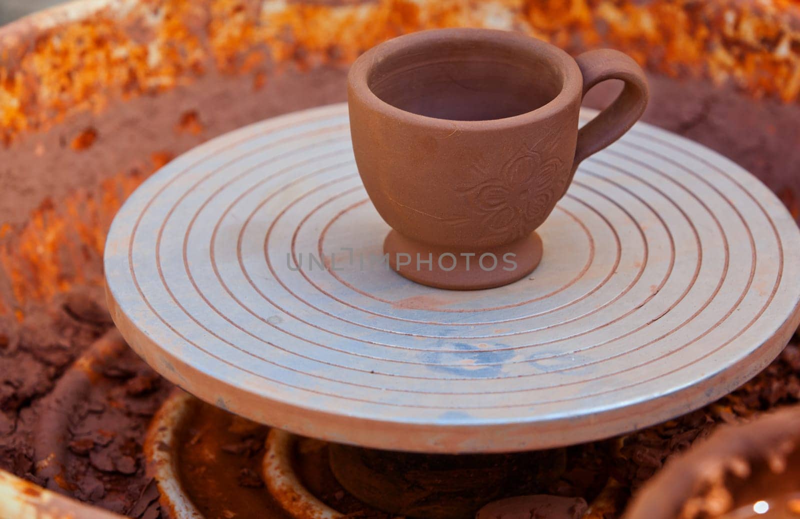 Close-up of decorated cup over potter's wheel