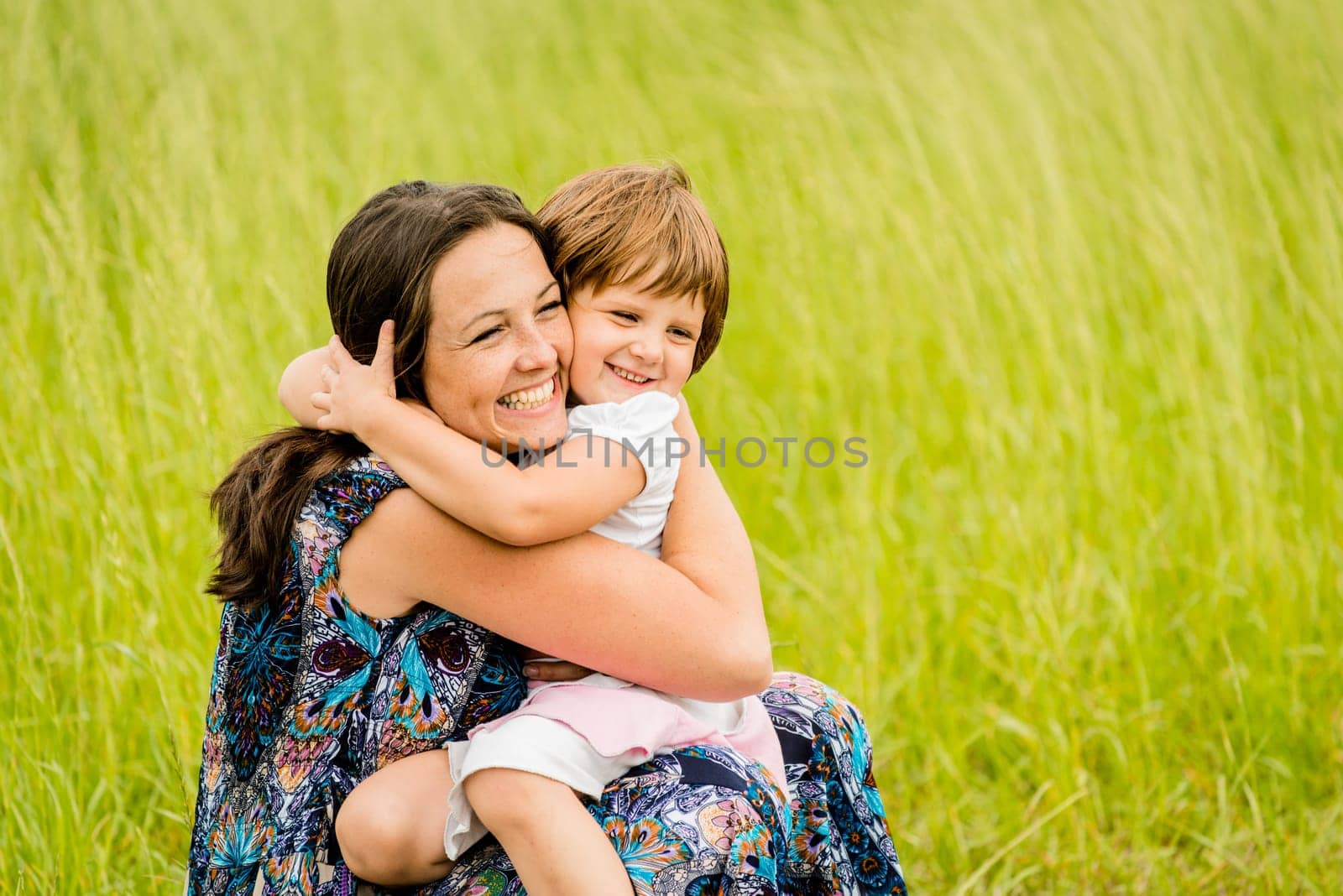 Mother and child are hugging and embracing outdoor in nature