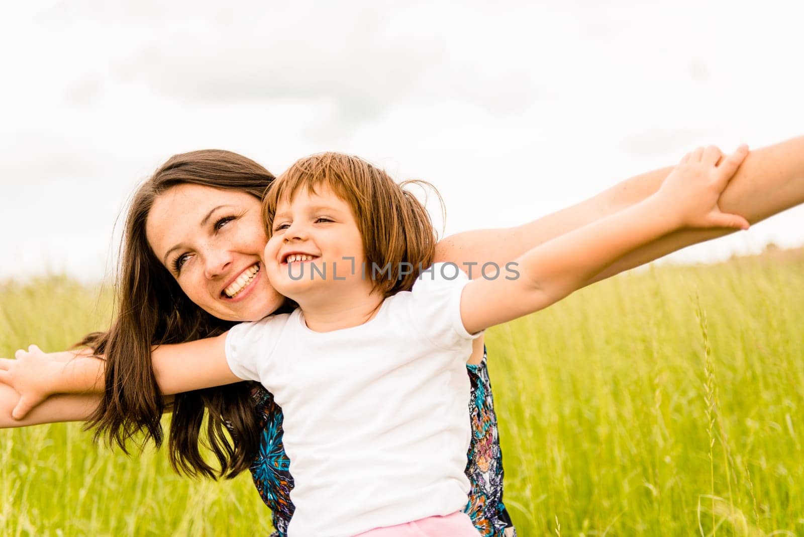 Mother and child pretend with hands they are together flying
