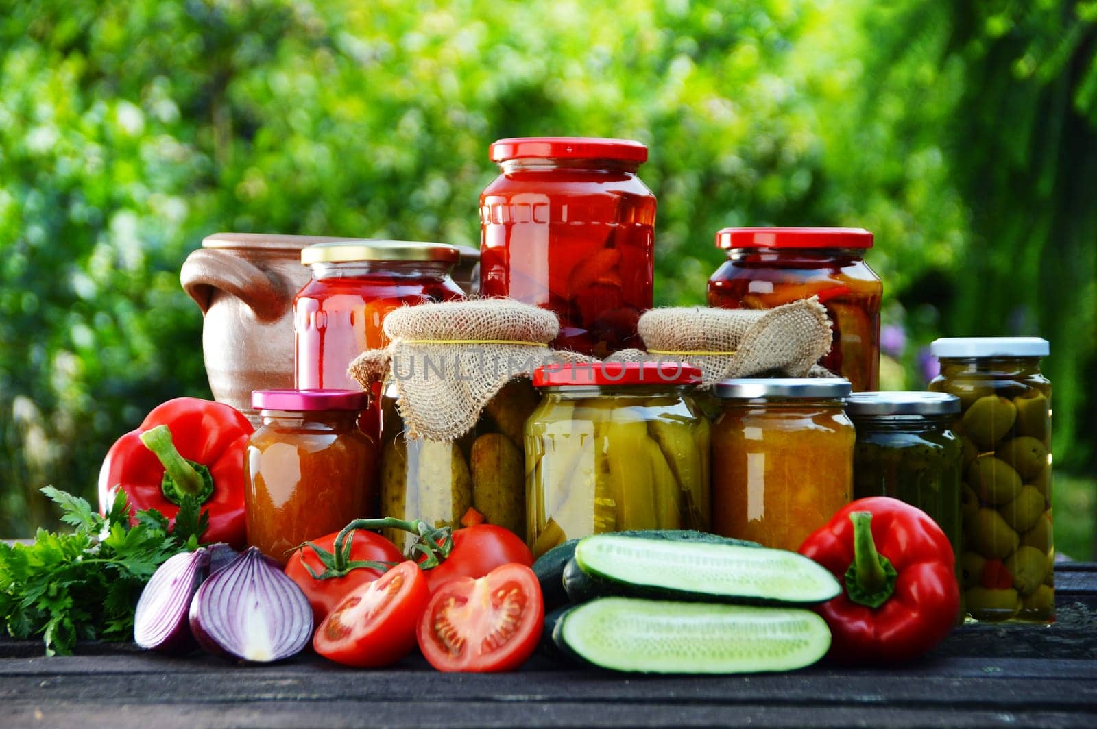 Jars of pickled vegetables in the garden. Marinated food.