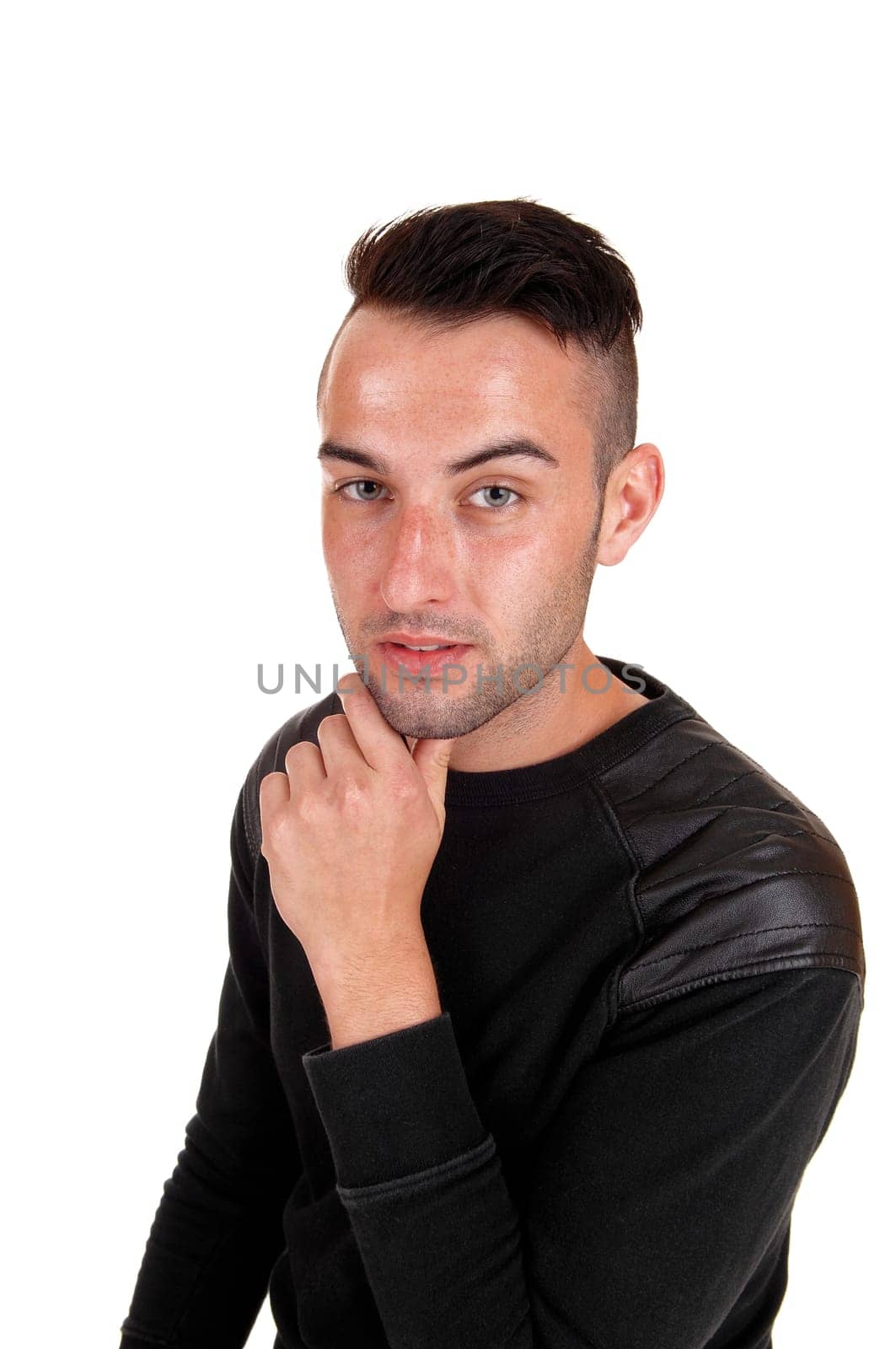A young handsome man in a profile picture in a black sweater with his hand.on his chin, isolated on white background..