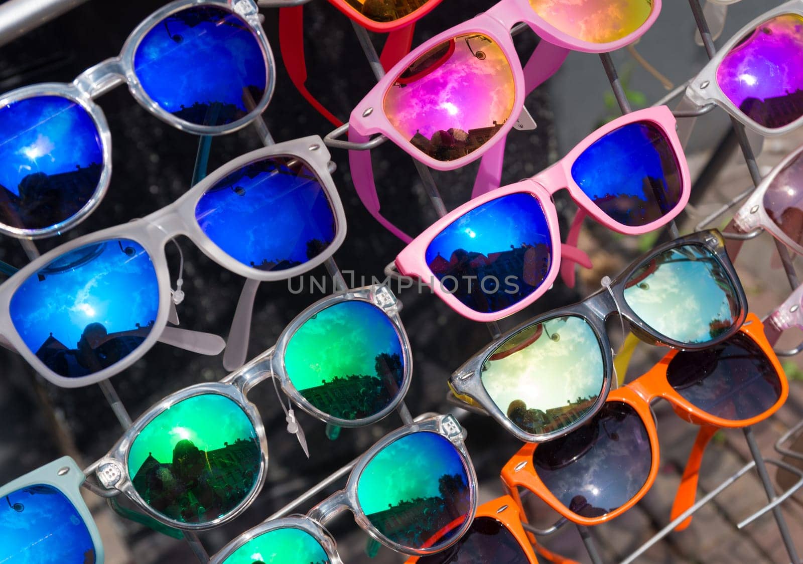 bunch of retro style sunglasses on a rack in front of a store