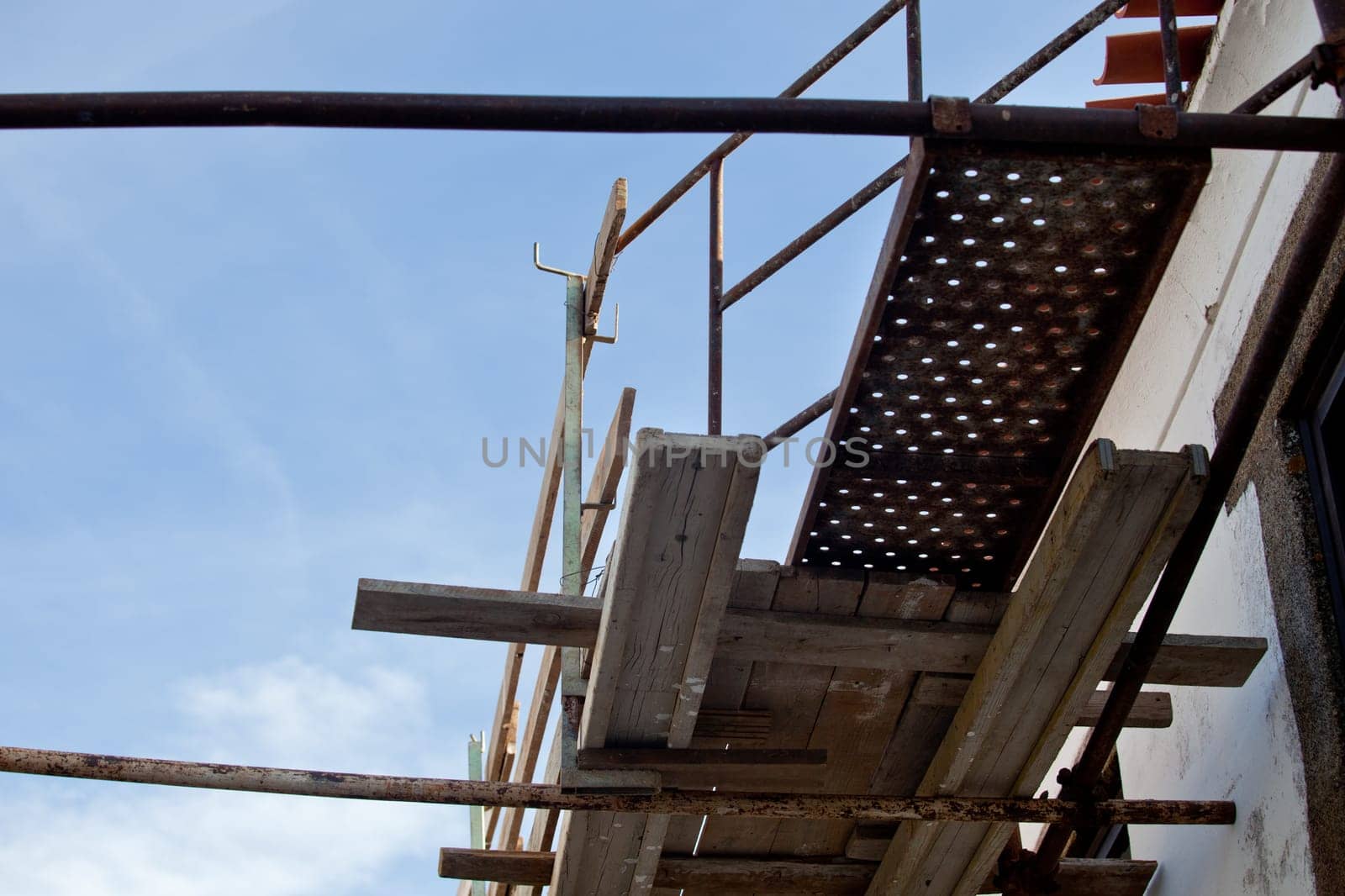 Rural building facade under reconstruction with old scaffoldings