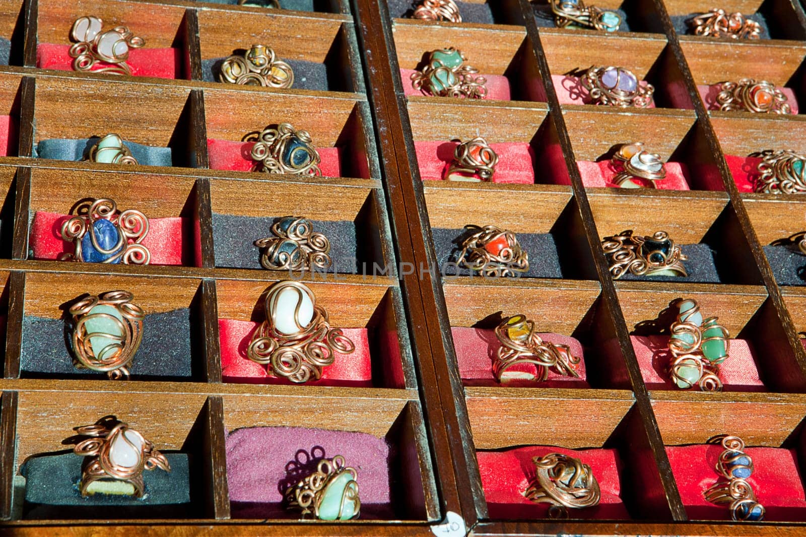 Colorful assortment of jewelry on wooden display full of rings