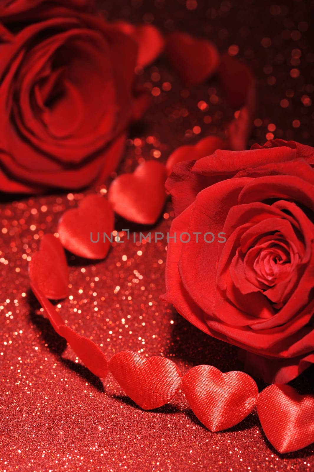 Chain of red fabric hearts with red roses on glitter background
