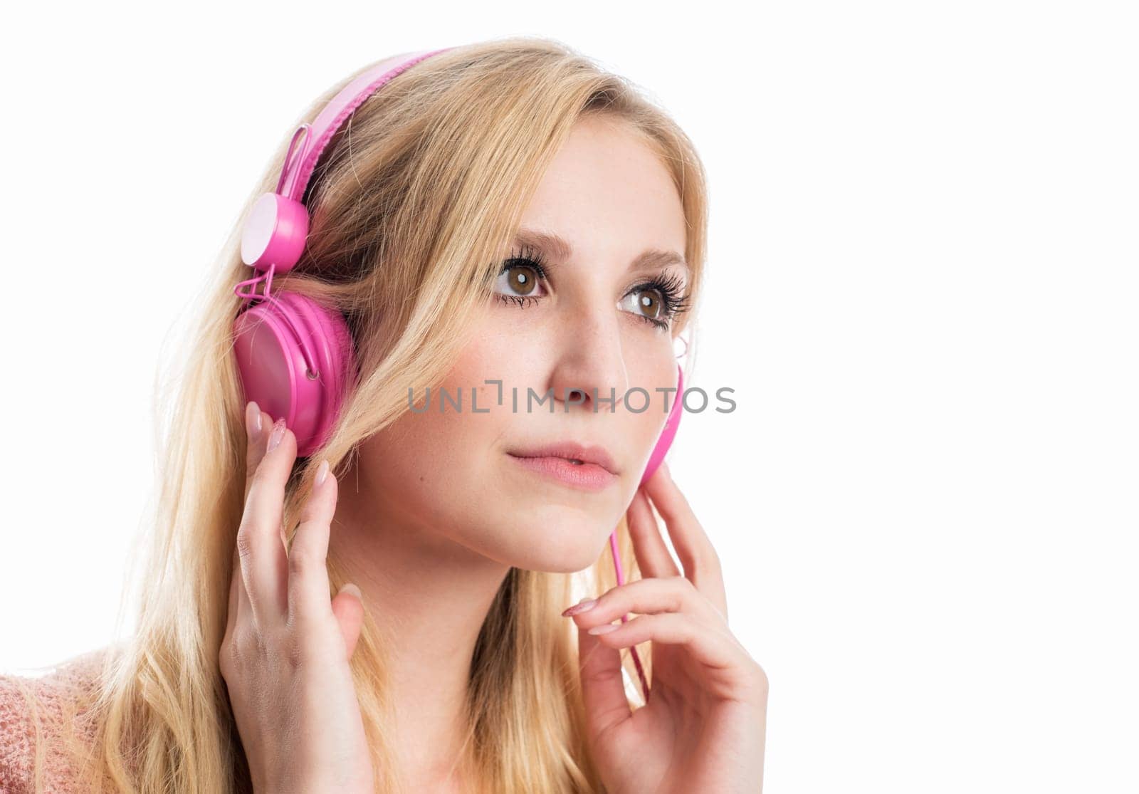 blonde young woman listens to music on the headphones