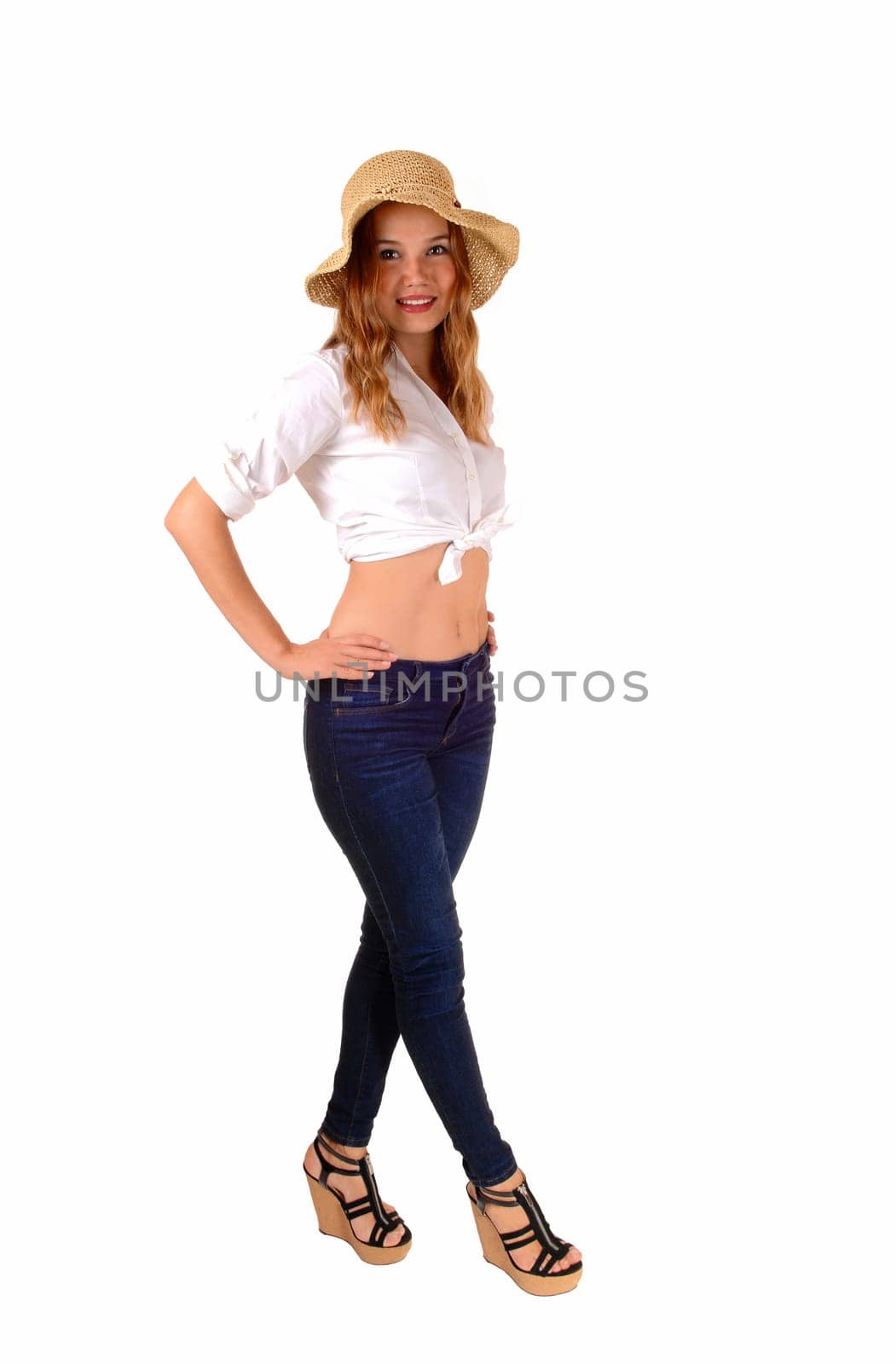 A beautiful slim woman in jeans and a white blouse, wearing a straw hat,.standing in full length isolated on white background..