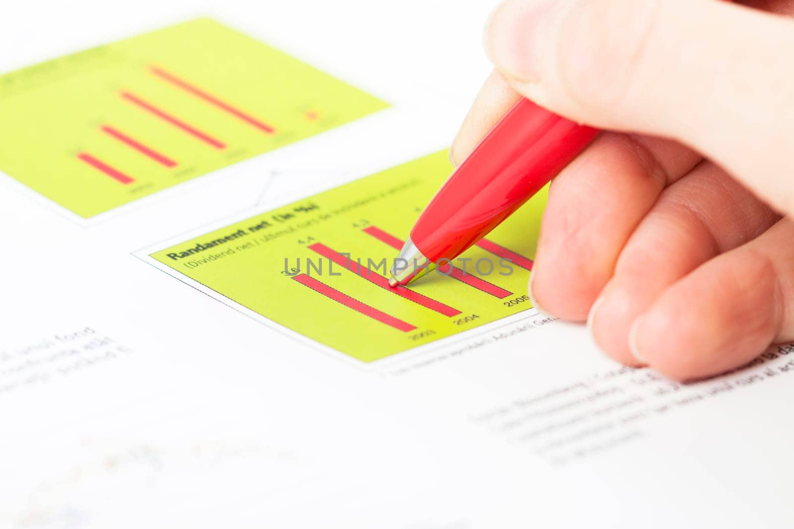 Close-up of female hand holding pen over business graph