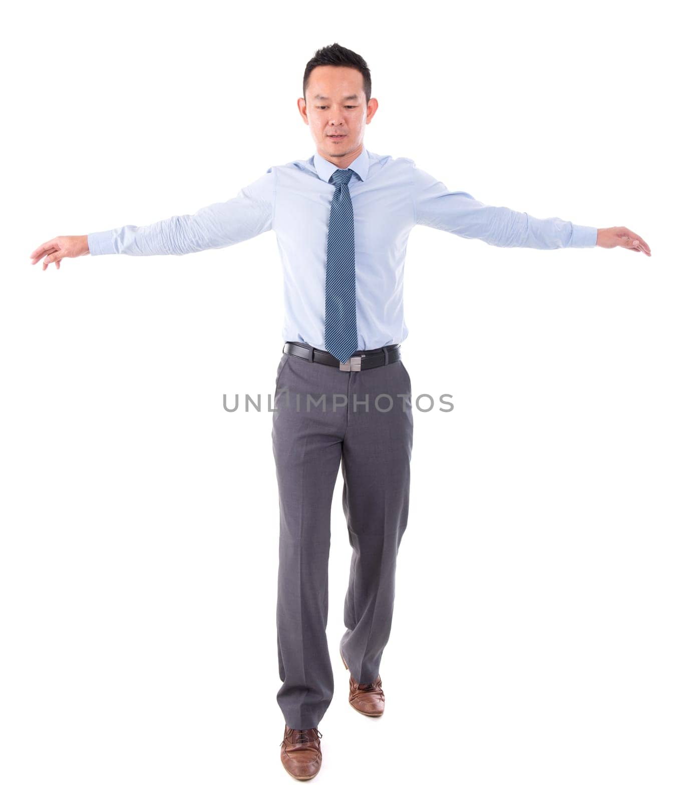 Asian business man walking balance, front view full length isolated over white background.