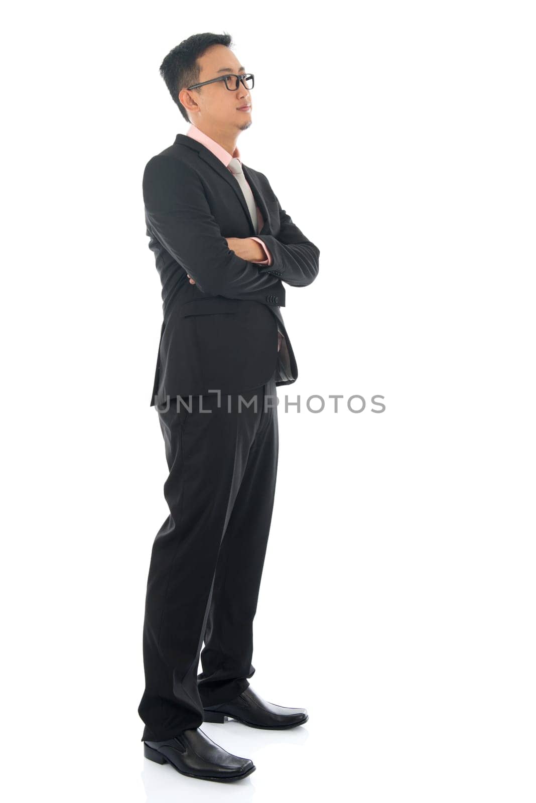 Full length confident southeast Asian business man crossed arms looking away standing isolated on white background.