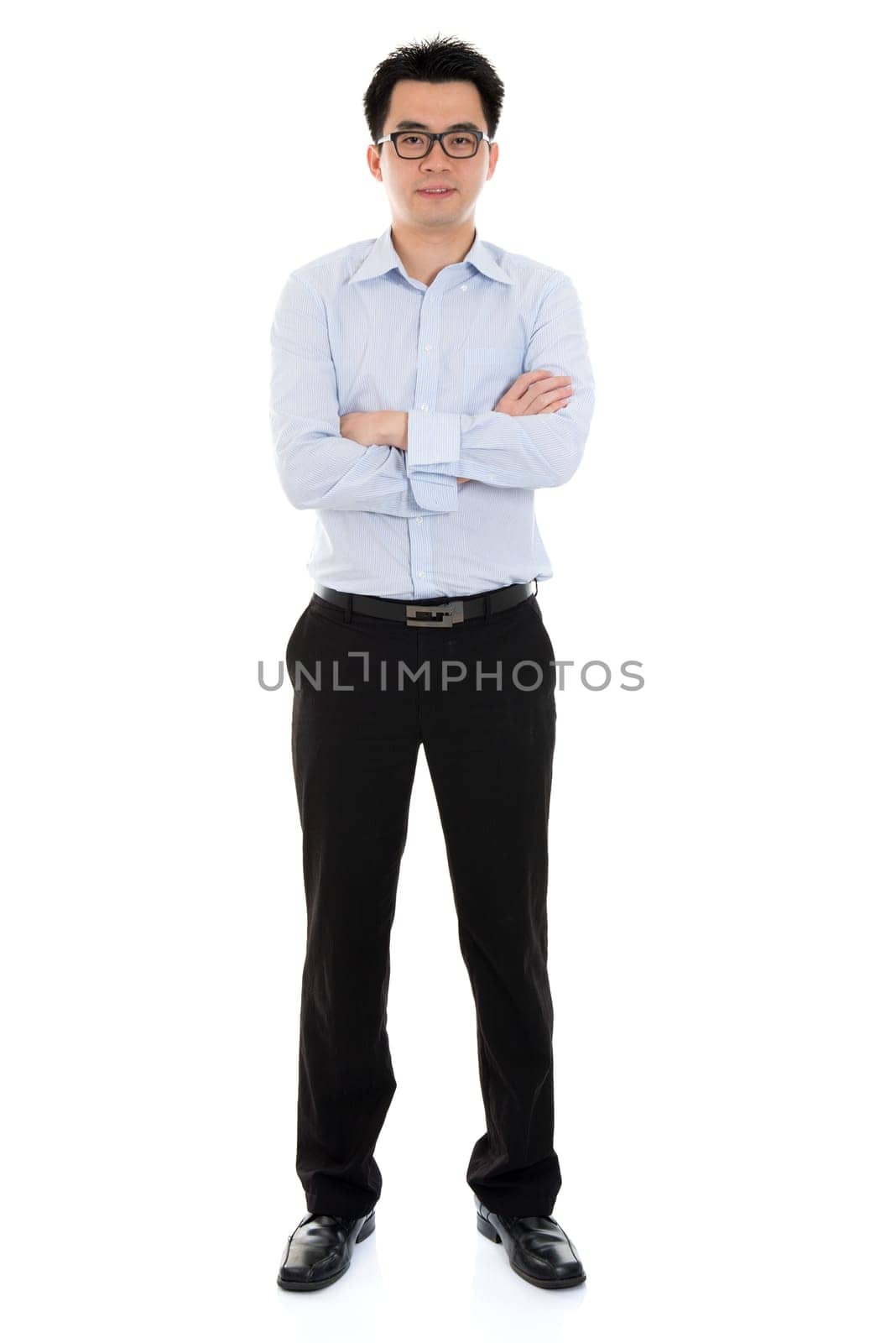 Full length Asian businessman arms crossed standing isolated on white background.
