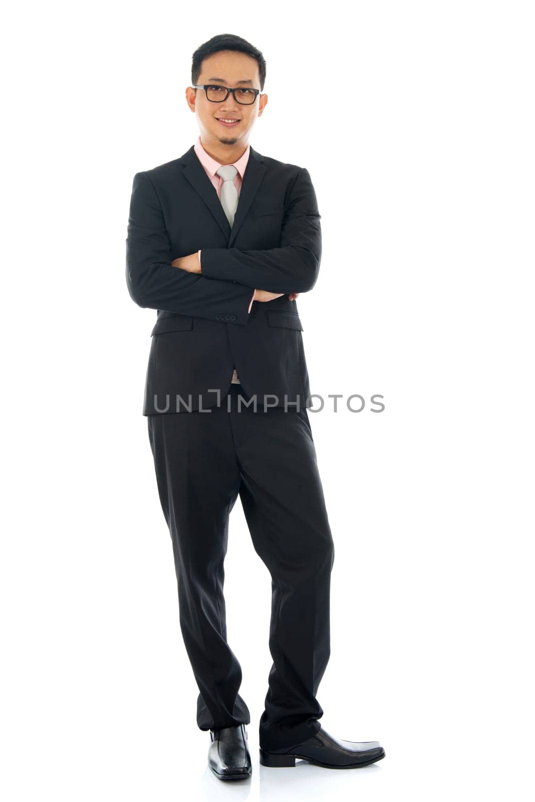 Full length pan Asian business man crossed arms standing isolated on white background.