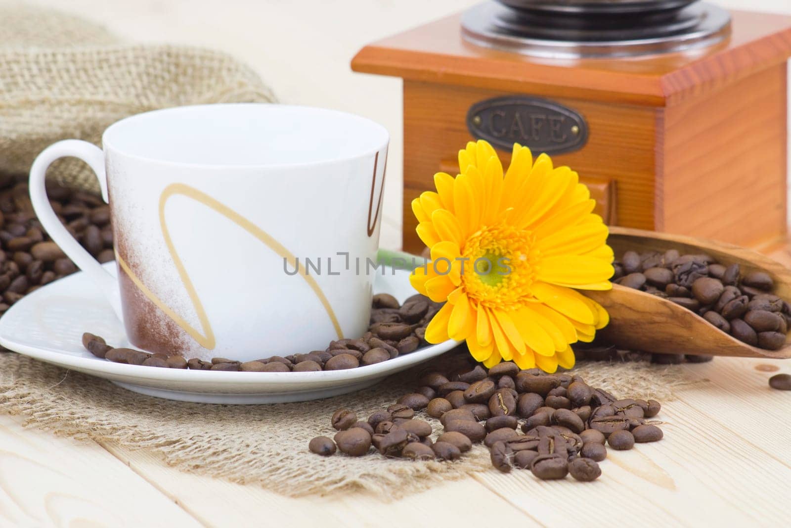 cup of coffee with yellow gerbera and coffee beans