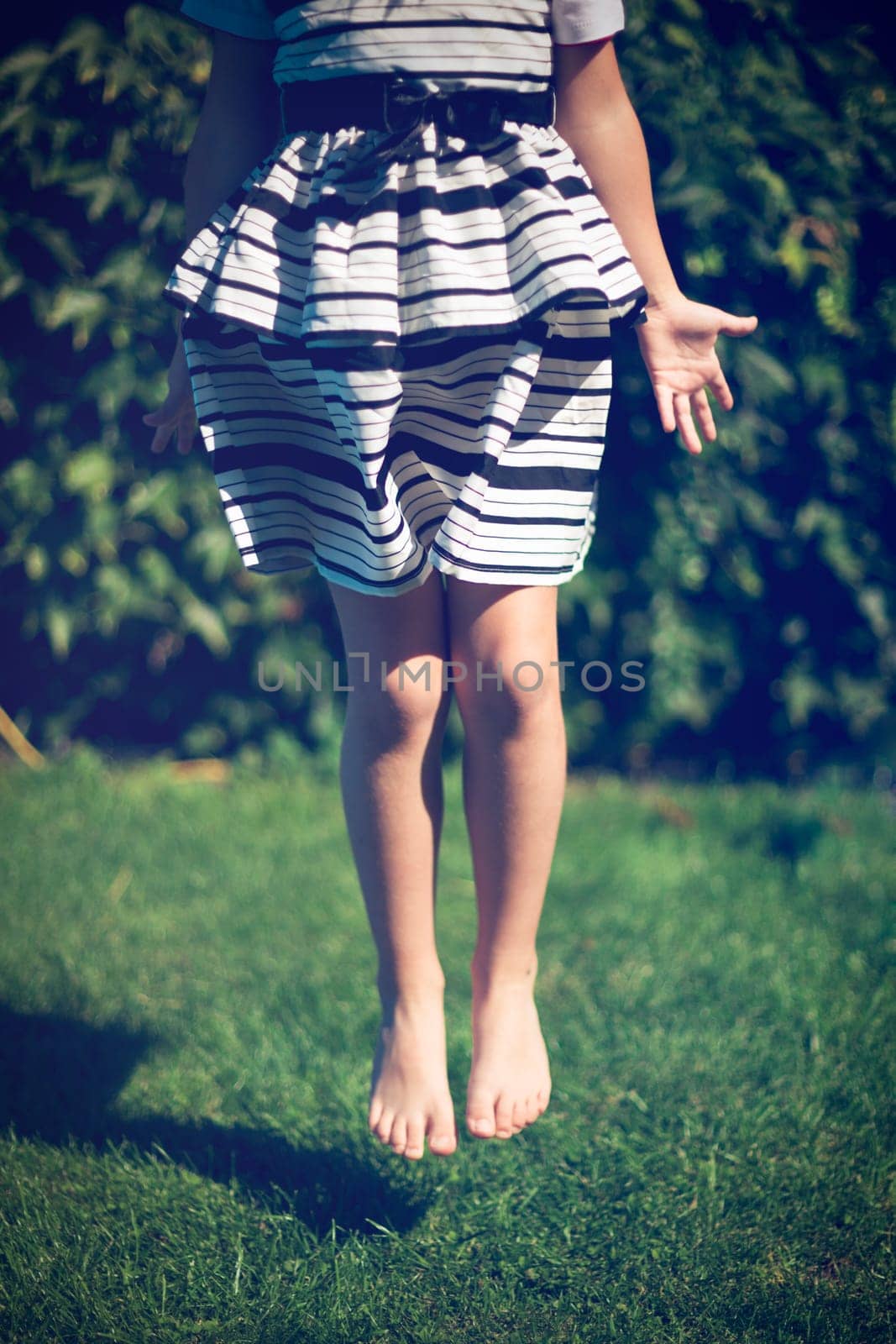 Little girl jumps. Exterior shot.