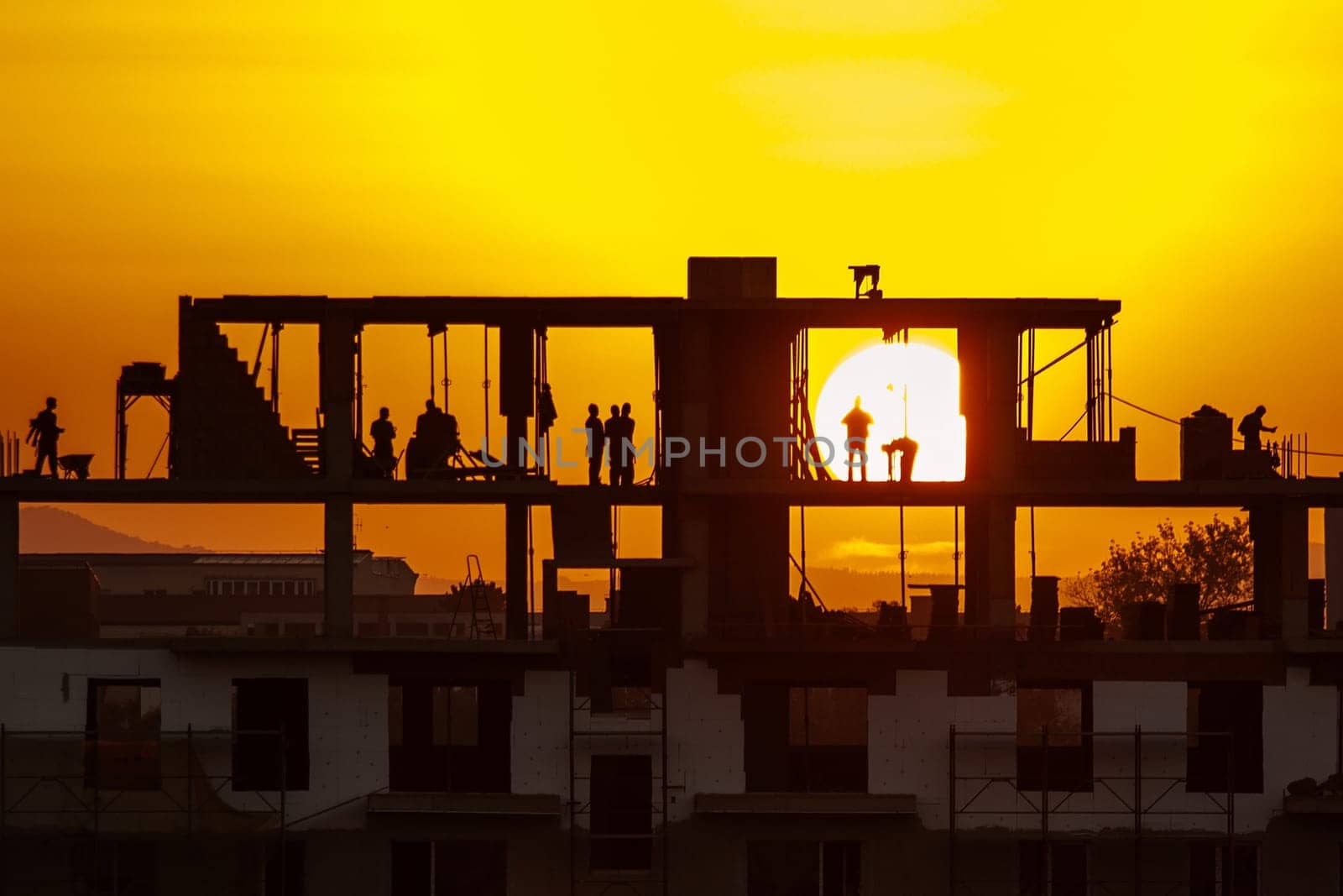 Silhouette of construction workers working on sunset