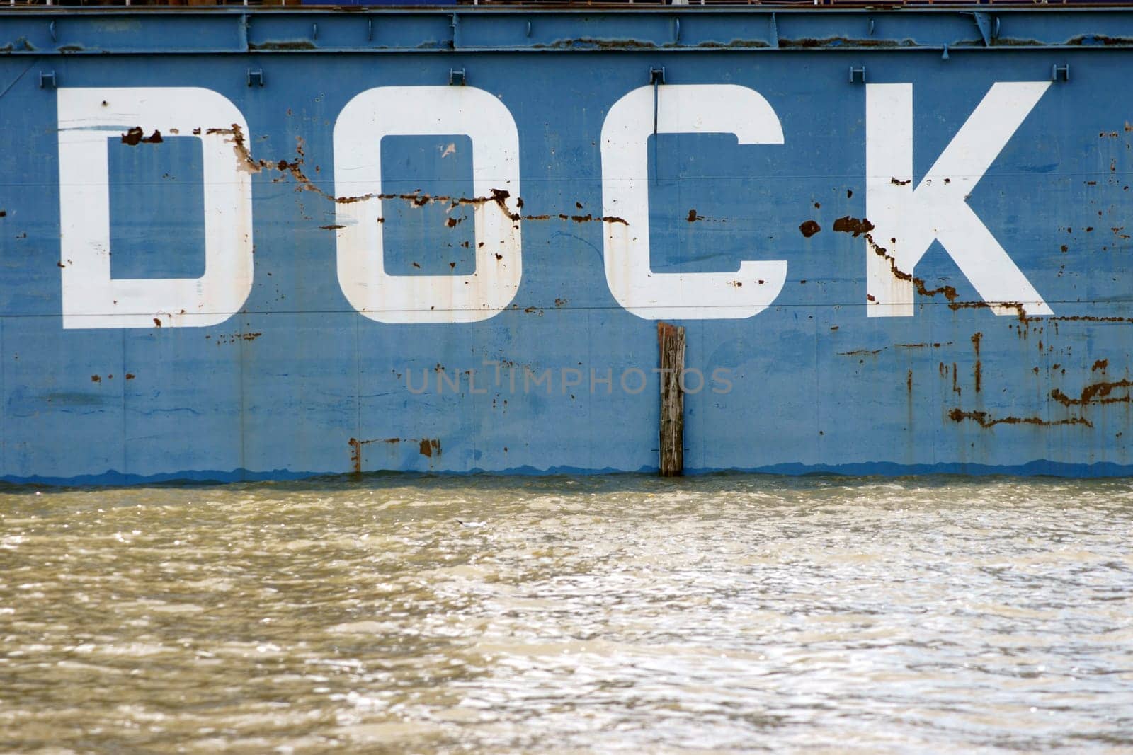 The furrowed and scratched photograph of the steel wall of a dock in the port of Hamburg.